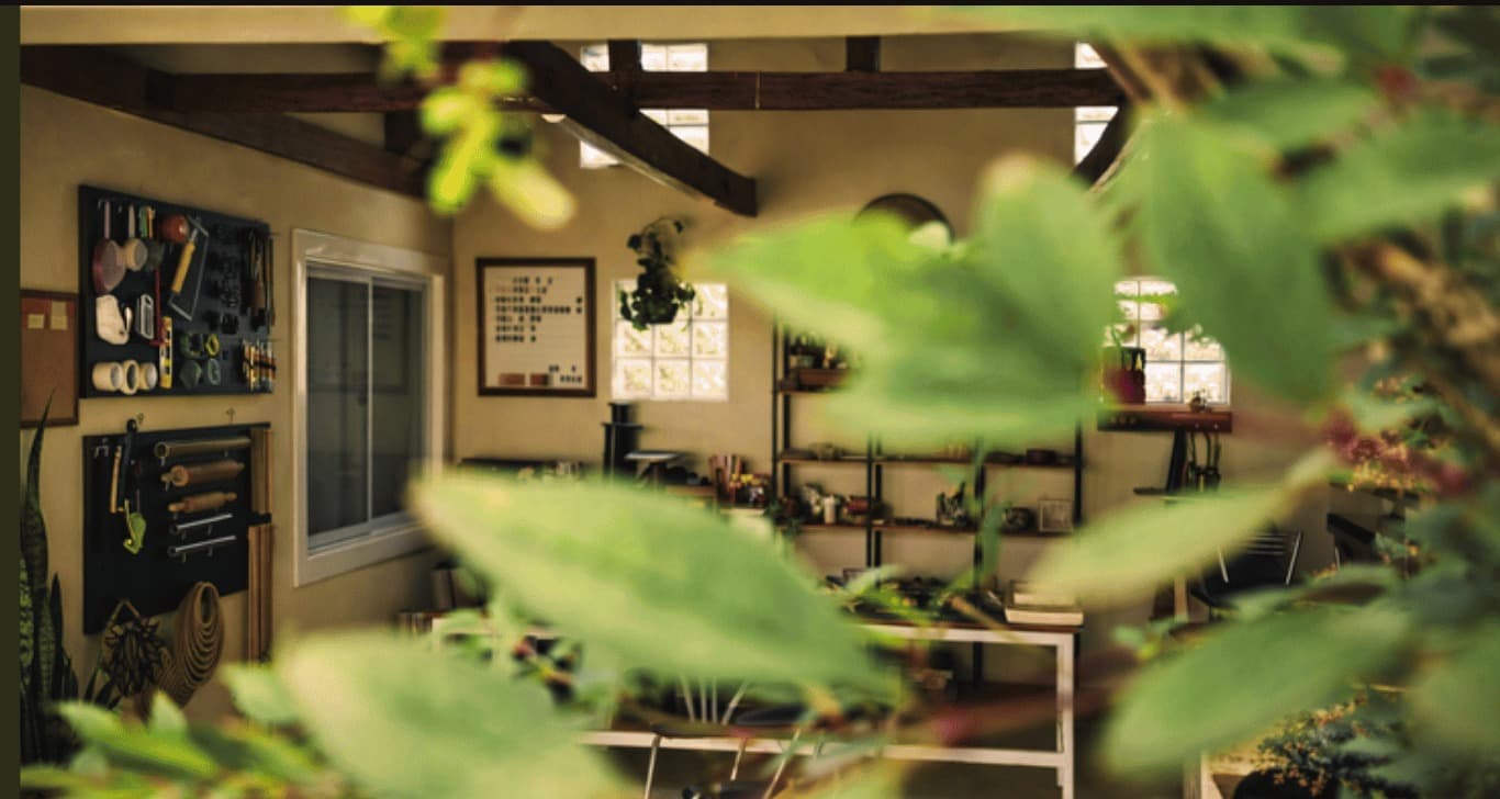 Ateliê de Flávia Ozik visto através de folhas verdes