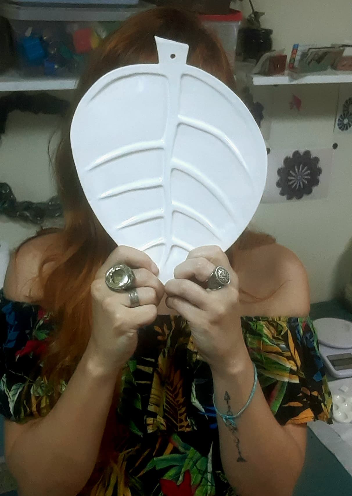 Flávia Ozik segurando uma peça cerâmica em formato de folha